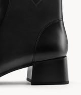 Detail shot of the sturdy 5cm block heel on women's black lambskin boots