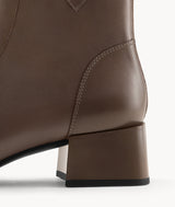 Close-up side view of the 5cm block heel on brown lambskin ankle boots