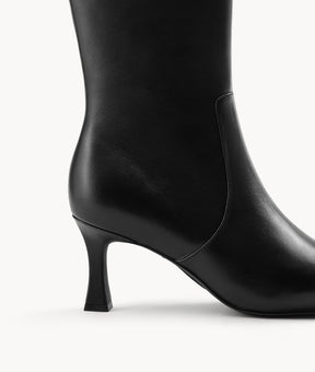 Close-up of the flared heel on women's black pointed-toe tall riding boots