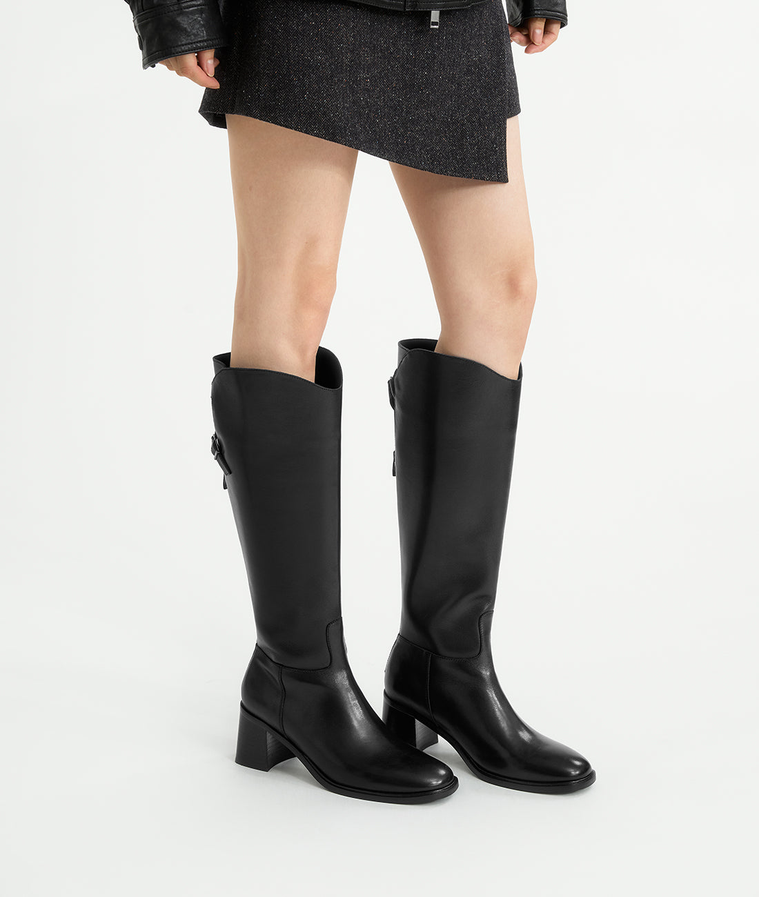 A model showcasing the winter-ready black riding boots, featuring a 7cm block heel, warm lining, and sleek profile
