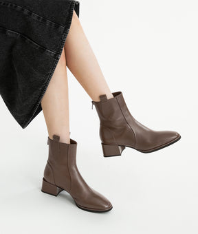 Close-up shot of the brown lambskin ankle boots with almond toe on foot
