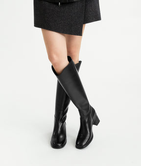 Model wearing the black cow leather riding boots with a block heel